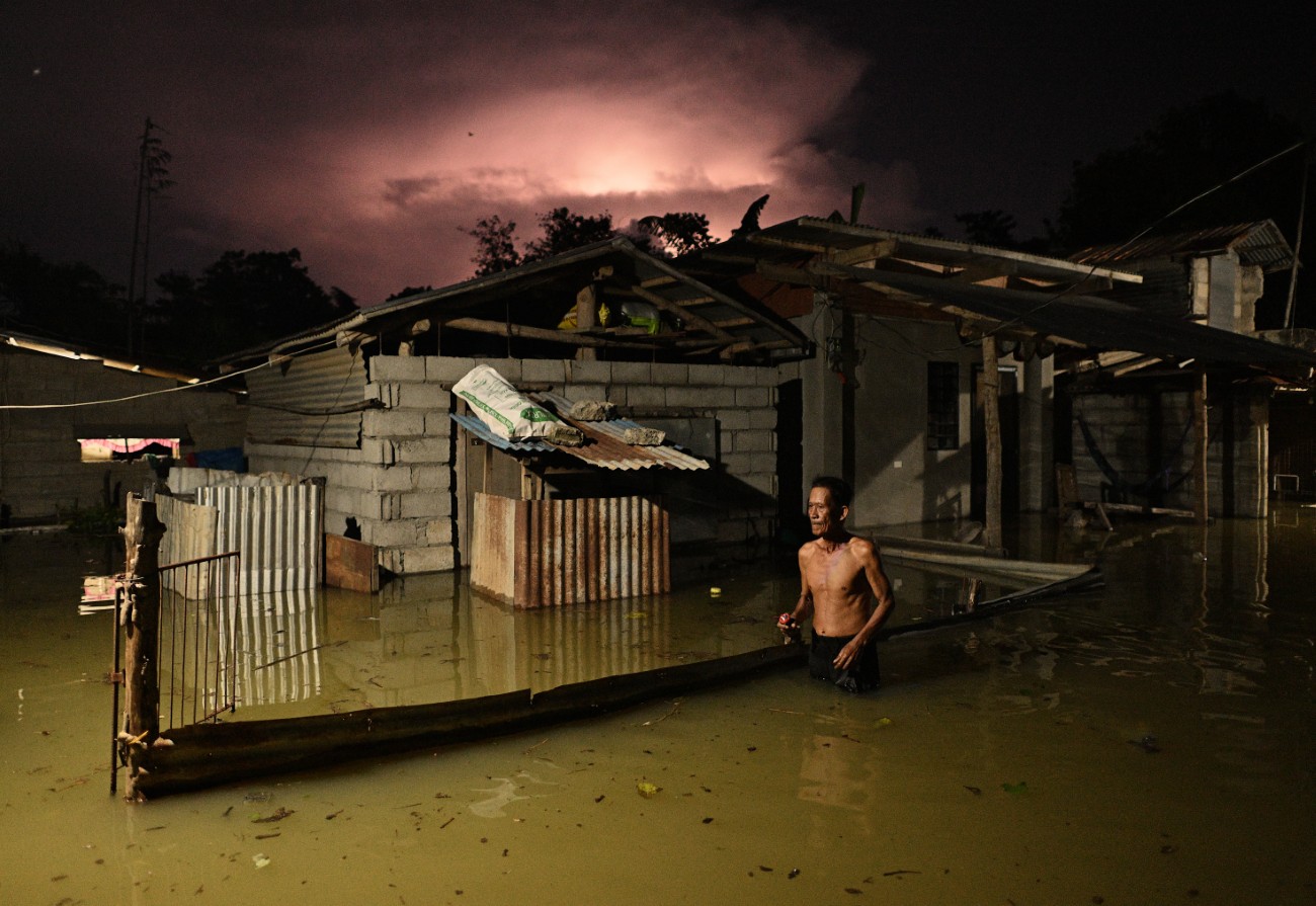 A man wades through a street flooded by heavy rains from Typhoon Toraij.